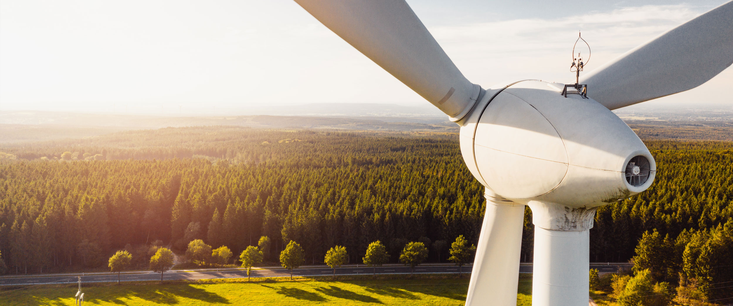 Windturbine steht auf Feld im Sonnenuntergang