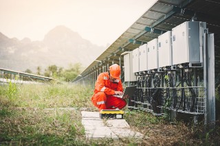 engineer or electrician holding laptop for inspect and checking string inverter by wifi technology ;smart technology for operate solar power plant