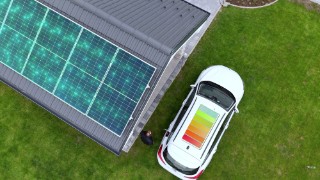 Charging Battery Icon On EV Roof Parked Outside House With Solar Panels